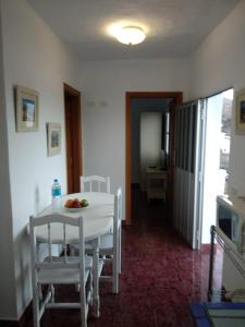 una mesa blanca y sillas en una habitación con cocina en Apartamento puerto estaca 3 en Puerto de la Estaca
