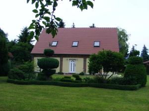 a house with a red roof and some bushes at Ferienwohnungen „Villa Havelblick“ in Rathenow