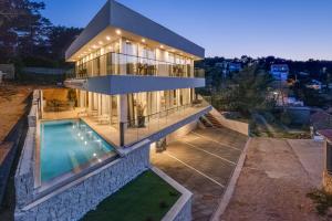 a large house with a swimming pool in front of it at Villa Estate Da Noi in Vrboska