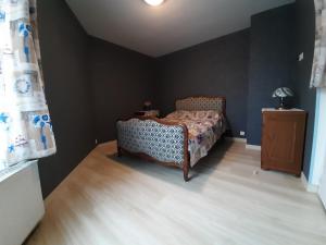 a bedroom with a bed and a wooden floor at aux hirondelles du lac in Le Mêle-sur-Sarthe