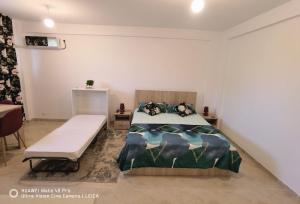 a bedroom with a bed and a bench in it at Studio Lorena in Mangalia