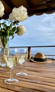 two glasses of white wine and a hat on a table at Mobil Home superbe Vue Mer St Raphaël in Saint-Raphaël