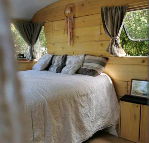 um quarto com uma cama e uma parede de madeira em GÎTE AZKENDANTZA 2a6 PERS AVEC CARAVANE INSOLITE em Ascain