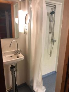 una ducha con cortina blanca junto a un lavabo en Erikssund en Erikssund