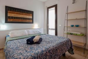 a bedroom with a bed with a blue blanket at Pergola 707 in Stintino