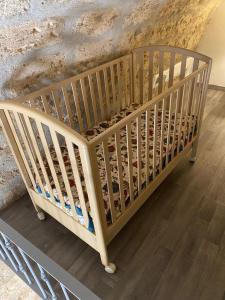 een houten wieg in een kamer met een muur bij Locazione Santa Rita in Molfetta +1 foto