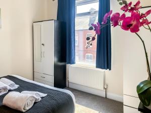 a bedroom with a bed and a window with blue curtains at The Victoria - Quaint Victorian Home With Free Parking in York