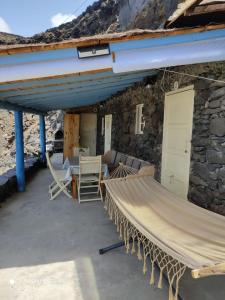 a patio with a hammock and chairs in front of a building at Casa Cueva el Pozo las Calcosas in Pozo de las Calcosas +23 photos