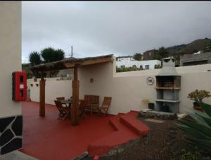 a patio with a table and chairs on a house at Casa Rural Aguarijo in Mocanal