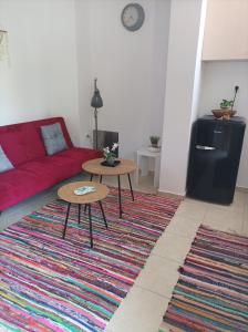 a living room with a red couch and two tables at Sable Blanc Apartments in Ixia +11 photos