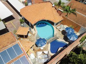 uma vista sobre uma piscina com guarda-sóis e cadeiras em Hotel Paraíso das Águas Bonito em Bonito