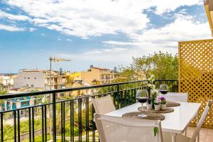 - un balcon avec une table et deux verres de vin dans l'établissement La Casa Di Stefe, à Giardini Naxos 9 autres photos
