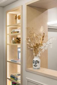 a book shelf with a vase with flowers in it at Black Door in Paris