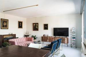 a living room with a table and a tv at Elegant Apt In The Historical Center Of Avignon in Avignon