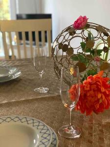 a table with two wine glasses and a vase with flowers at Mitten im Ruhrgebiet immer Willkommen, wlan , Netflix, Parking Free, 100m2 flat in Oberhausen