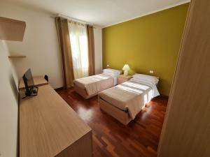 a hotel room with two beds and a television at Nel Sole appartamenti in Bologna