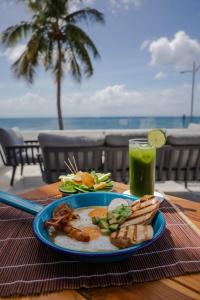 un piatto di cibo su un tavolo con una bevanda di Hotel Puerto Libre a Cozumel