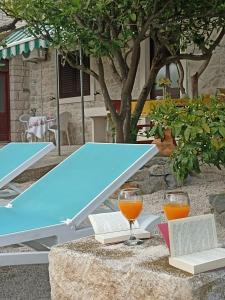 einen Tisch mit 2 Gläsern Orangensaft und Büchern in der Unterkunft Apartment Pojatica Sumartin in Sumartin