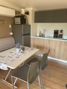 - une cuisine avec une table et des chaises dans la chambre dans l'établissement Mobile Homes Dololego - Camp Baško Polje, à Baška Voda