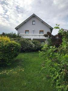 Gästehaus Elisabeth في Weisenheim am Sand: منزل أبيض مع ساحة خضراء