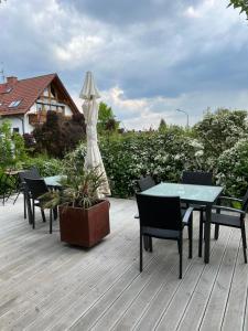 un patio con mesa, sillas y sombrilla en Gästehaus Elisabeth, en Weisenheim am Sand