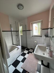y baño con bañera, lavamanos y bañera. en Gästehaus Elisabeth, en Weisenheim am Sand