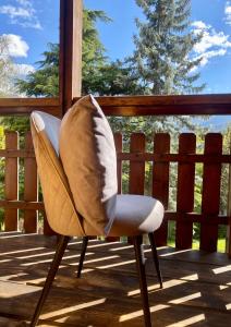 une chaise avec un oreiller sur la terrasse dans l'établissement Chalet Bormio Terme, à Bormio