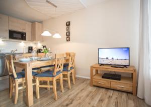 eine Küche und ein Esszimmer mit einem Tisch und einem TV in der Unterkunft Bike & Ski kappe, am Bikepark, Skilift in Winterberg