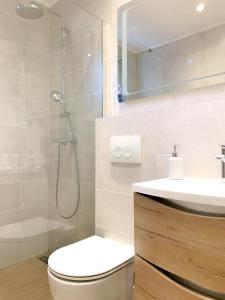 ein Bad mit einer Dusche, einem WC und einem Waschbecken in der Unterkunft G Apartment in Podstrana