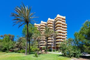 a building with palm trees in front of it at Salamar Saler Golf in El Saler