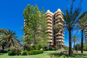a building with palm trees in front of it at Salamar Saler Golf in El Saler