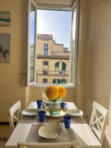 a table with a vase of flowers and a window at Domus Lido in Lido di Ostia