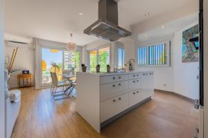 a kitchen with white cabinets and a dining room at Salamar Saler Golf in El Saler