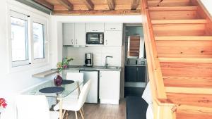a small kitchen with a glass table in a tiny house at Del Sol Suites in Skiathos