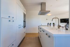 a kitchen with white cabinets and a sink at Salamar Saler Golf in El Saler