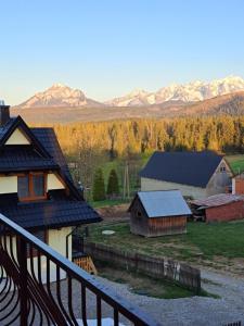 Vistas a una casa con montañas en el fondo en Apartament Sichlański, en Murzasichle