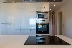 a kitchen with white cabinets and a microwave at Salamar Saler Golf in El Saler