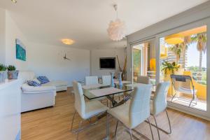 a dining room and living room with a table and chairs at Salamar Saler Golf in El Saler