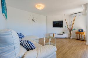 a living room with a couch and a clock on the wall at Salamar Saler Golf in El Saler