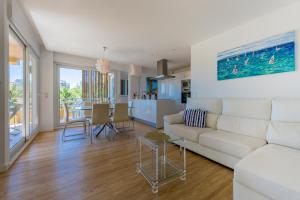 a living room with a white couch and a kitchen at Salamar Saler Golf in El Saler