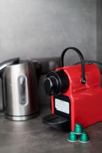 a red toaster sitting on a counter next to a kettle at 2 pièces neuf au pied des musées - wifi & parking gratuit in Grasse
