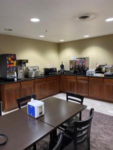 a cafeteria with a table with a microwave on it at AmericInn by Wyndham Maquoketa in Maquoketa