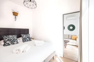 Habitación blanca con cama y espejo en 2 pièces neuf au pied des musées - wifi & parking gratuit, en Grasse