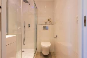 a white bathroom with a toilet and a shower at Salamar Saler Golf in El Saler