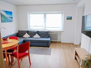 a living room with a blue couch and a table at Helena Ferienwohnung in Hemfurth-Edersee