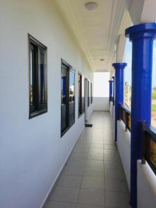 a hallway with blue columns and windows in a building at Villa Cocotiers A11 in Cotonou