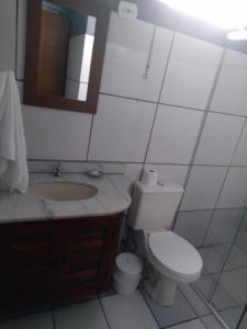a bathroom with a toilet and a sink and a mirror at Pousada Maanaim 2 in Ubatuba