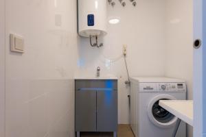 a bathroom with a washing machine and a sink at Salamar Saler Golf in El Saler
