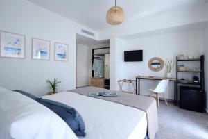 a bedroom with a white bed and a desk at ALMYRA seafront residence in Lygia