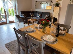 a dining room with a table with chairs and a couch at Domek wakacyjny in Pogorzelica